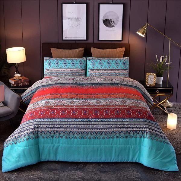Colorful patterned bedspread on a neatly made bed in a cozy bedroom with lamps and framed wall art