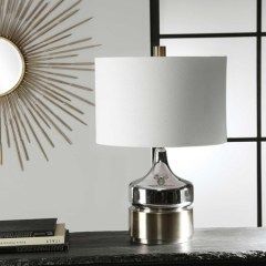 Modern table lamp with white shade and chrome base on a dark surface in a stylish room