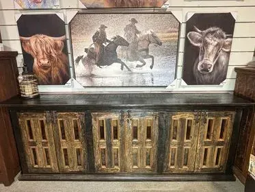 Rustic console with gold cabinet doors and three framed western horse and bull paintings above