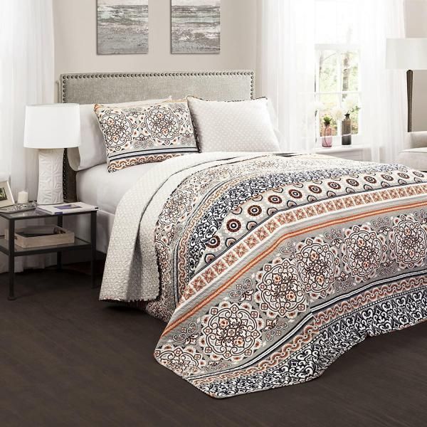 Modern bedroom with a neatly made bed, patterned duvet, lamps, and soft neutral decor