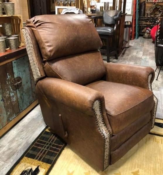 Brown leather recliner with nailhead trim in a rustic furniture showroom