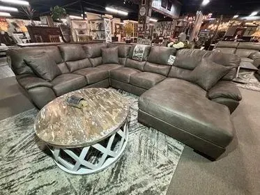 Sectional leather sofa with ottoman and round coffee table in a furniture showroom