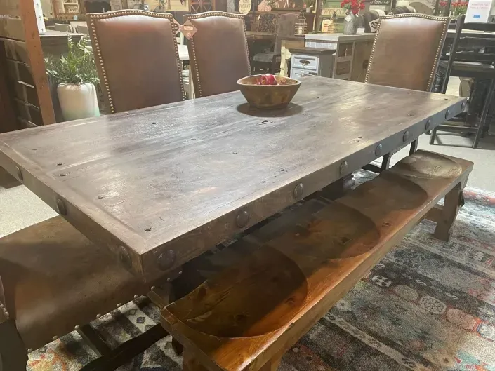 Wooden dining table with chairs and a bowl centerpiece in a cozy rustic interior