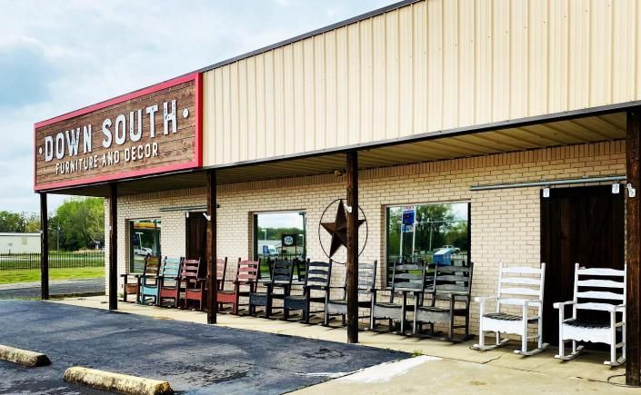 Storefront with “Down South” sign, covered porch, and white rocking chairs along the front.