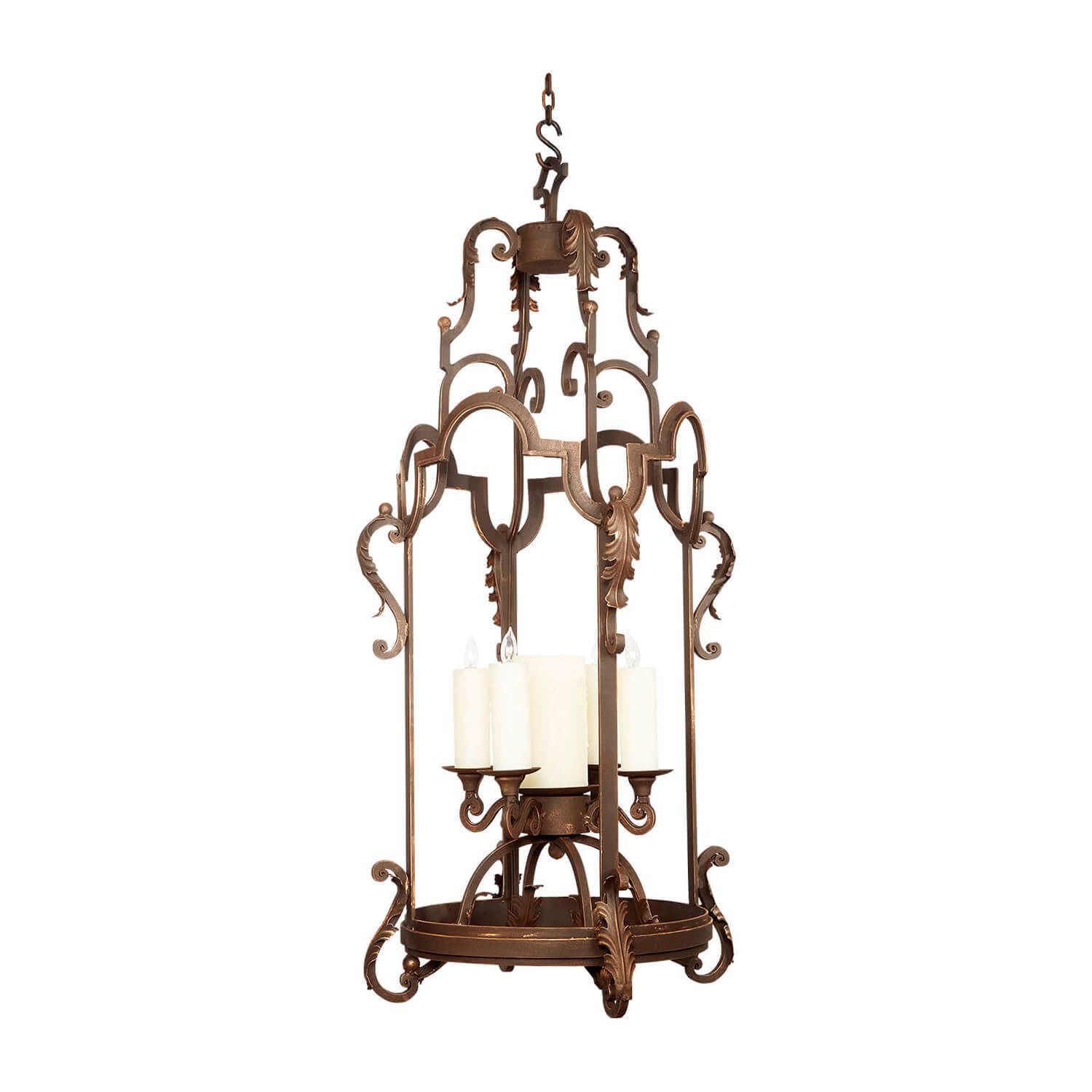 Ornate bronze chandelier with six white candle-style lights on a white background