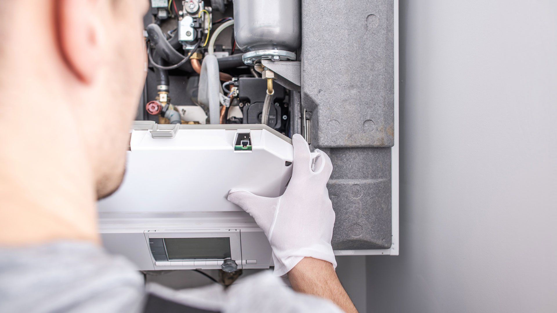 Man Checking the Furnace — Pueblo West, CO — Total Service Heating, Air Conditioning & Refrigeration Inc.