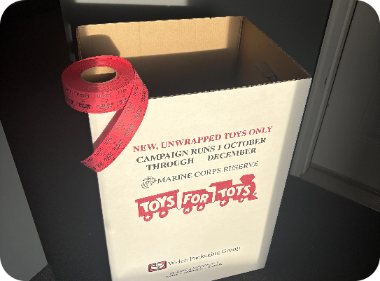 A cardboard box that says toys for tots on it