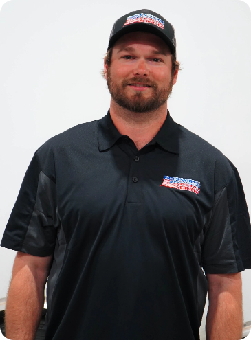 A man with a beard wearing a black shirt and a hat