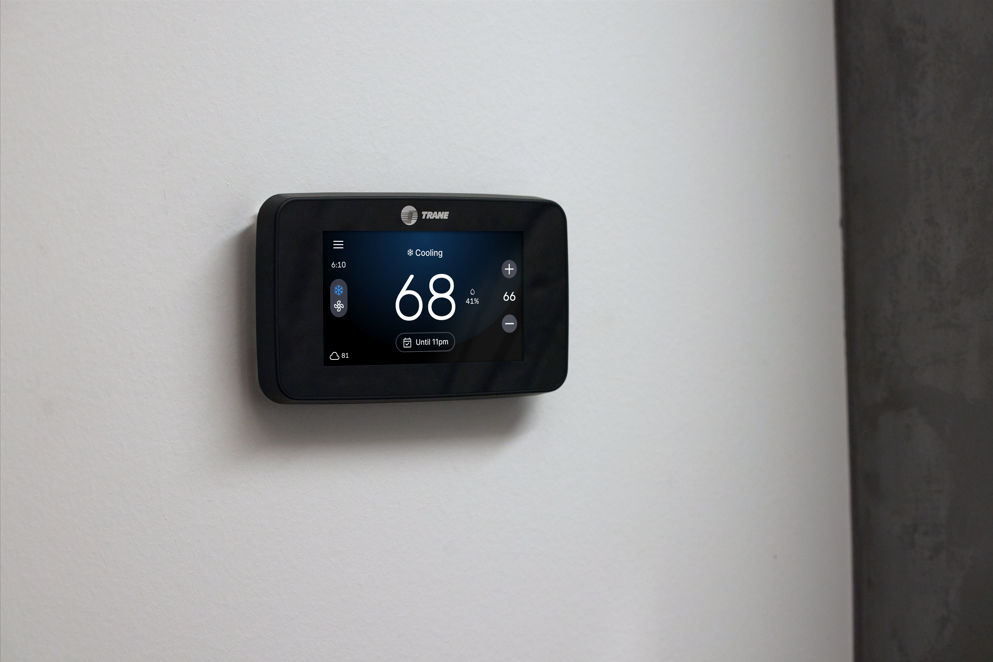 White thermostat display showing the time, set temperature, and room temperature.
