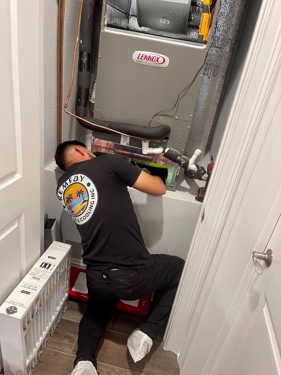 A furnace and water heater are in a utility room. The appliances are gray and white against a light yellow wall.