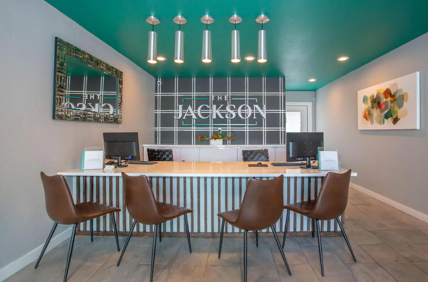 Modern dining room with teal ceiling, long table, and bar stools beneath pendant lights