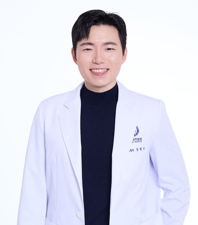 A smiling woman wearing a white lab coat, arms crossed, stands against a white background.
