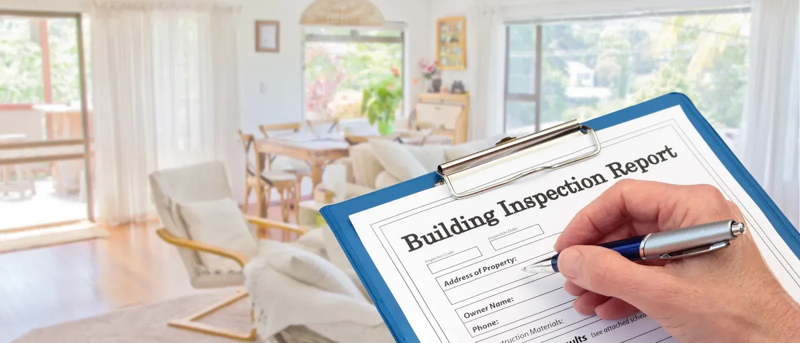 A person is writing a building inspection report on a clipboard.