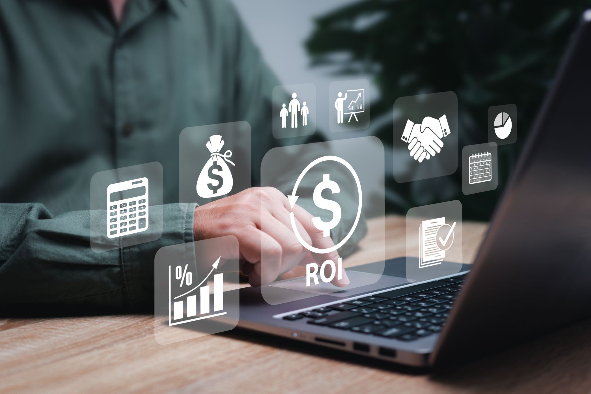 Businessperson using laptop with floating finance and analytics icons