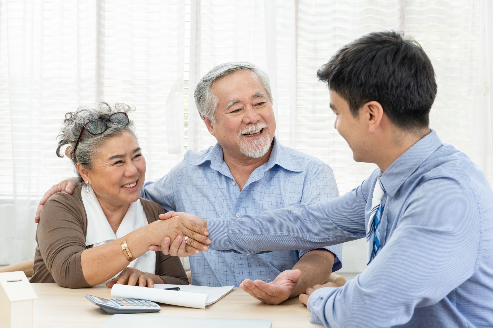 Senior Couple Shaking Hands With Their Financial Advisor