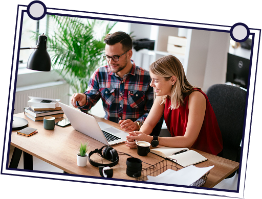 Man and woman looking at laptop screen together at a desk.