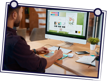 Man using a digital drawing tablet at a computer, designing with color palette, office desk.
