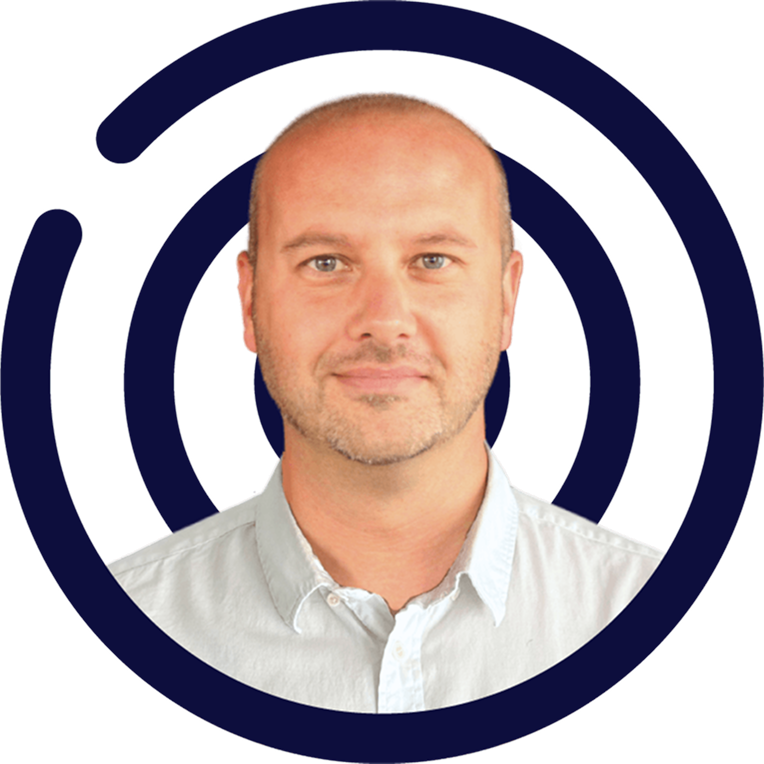 Man with shaved head and light blue shirt inside navy concentric circle graphic.