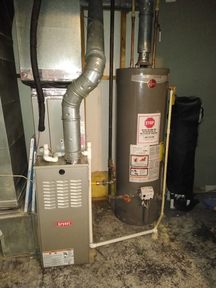 Gas furnace and water heater in a basement utility area with exposed ductwork and pipes.