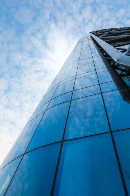 Looking up at a tall building with a blue sky in the background