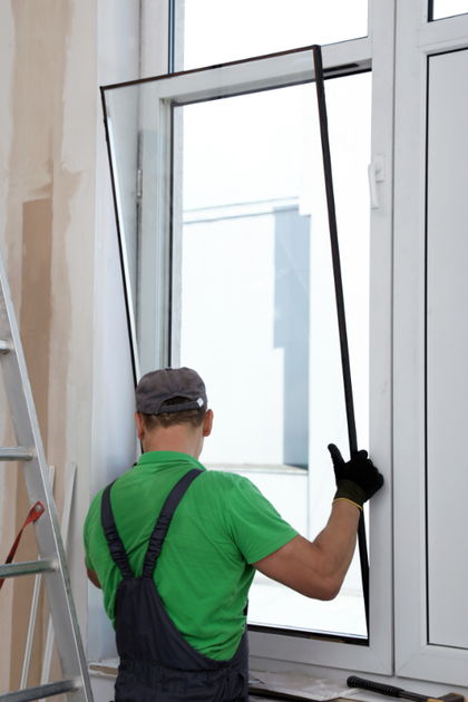 A man is installing a new window in a room.
