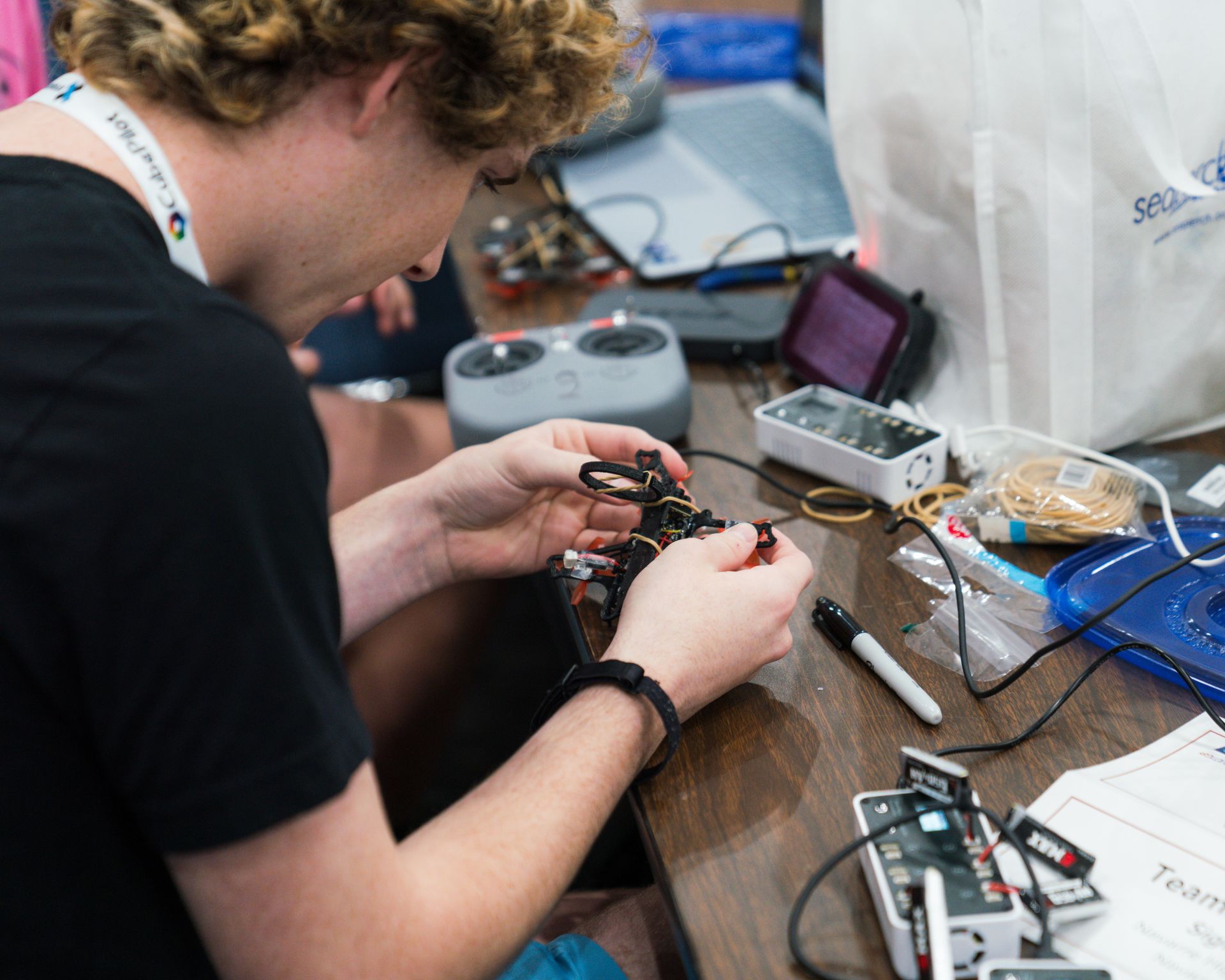 A man is working on a remote control at a table.