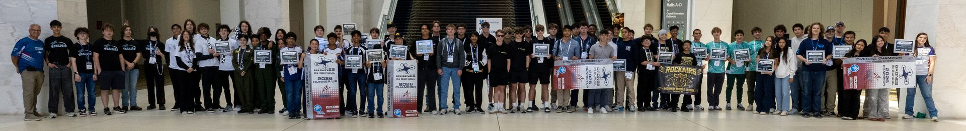 A large group of people are posing for a picture in front of a sign that says houston
