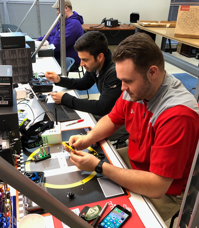 A man in a red shirt is working on a computer
