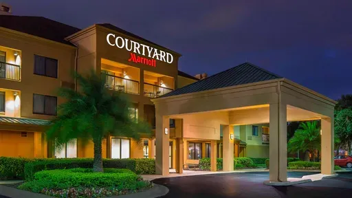The courtyard marriott hotel is lit up at night.