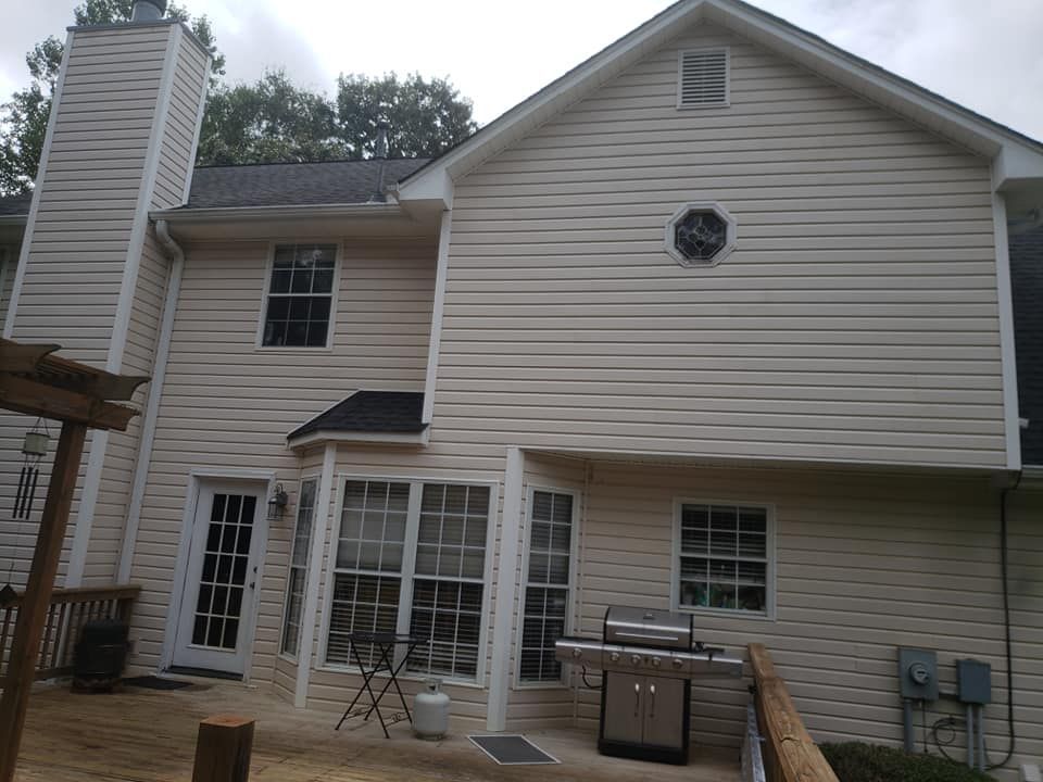 The back of a house with a grill on the deck