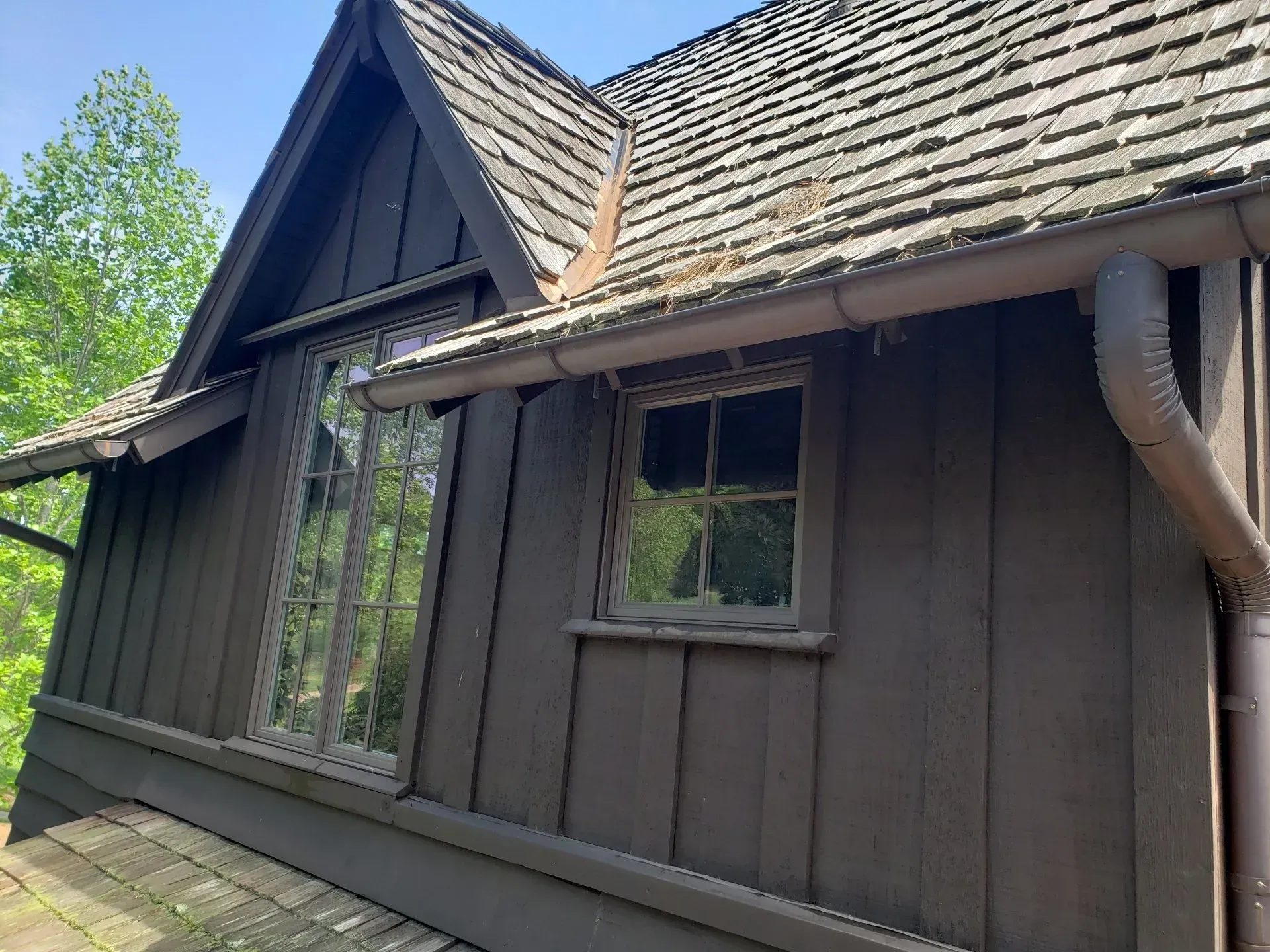 The side of a house with a roof and a window.