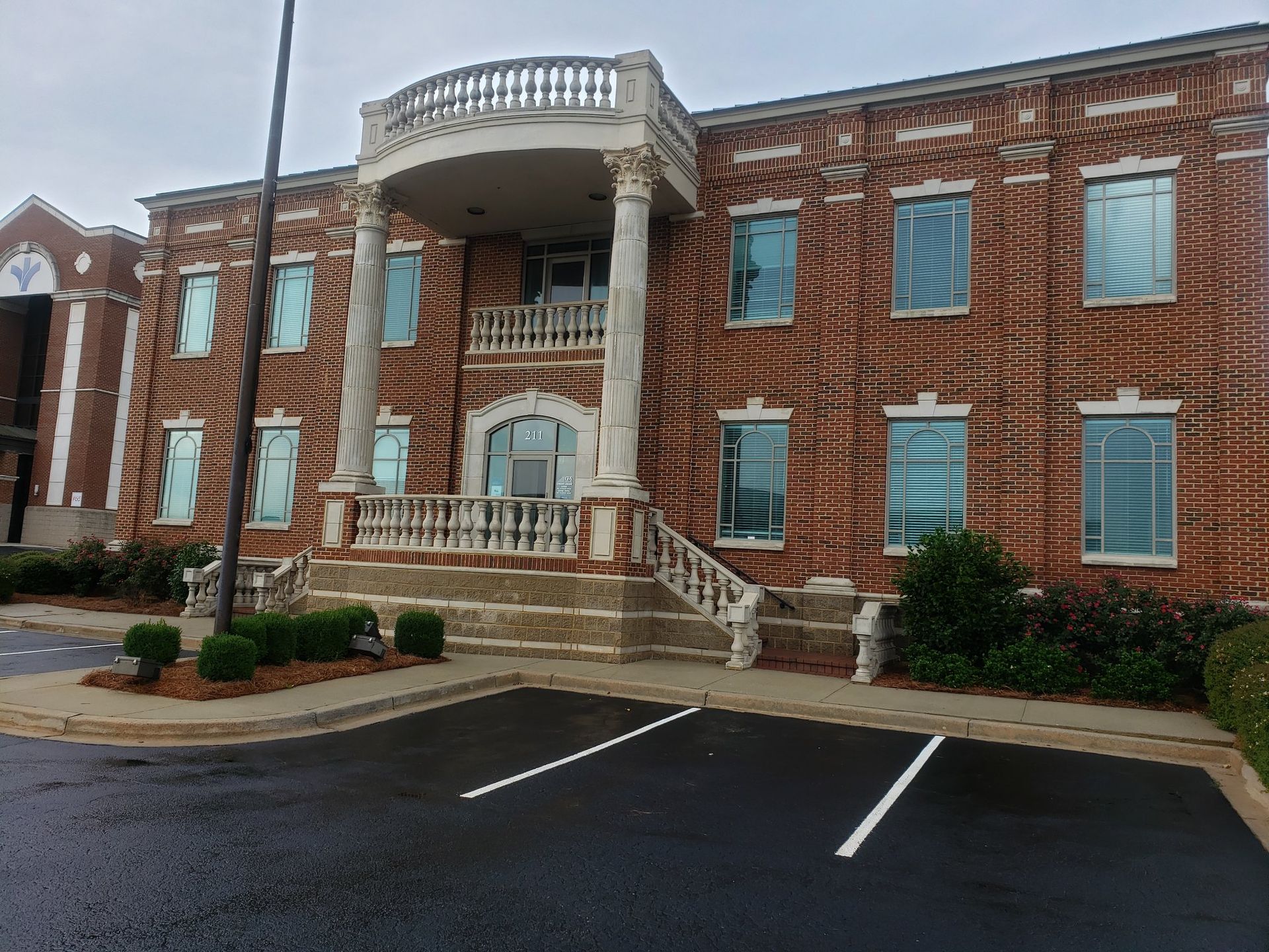 A large brick building with a parking lot in front of it.