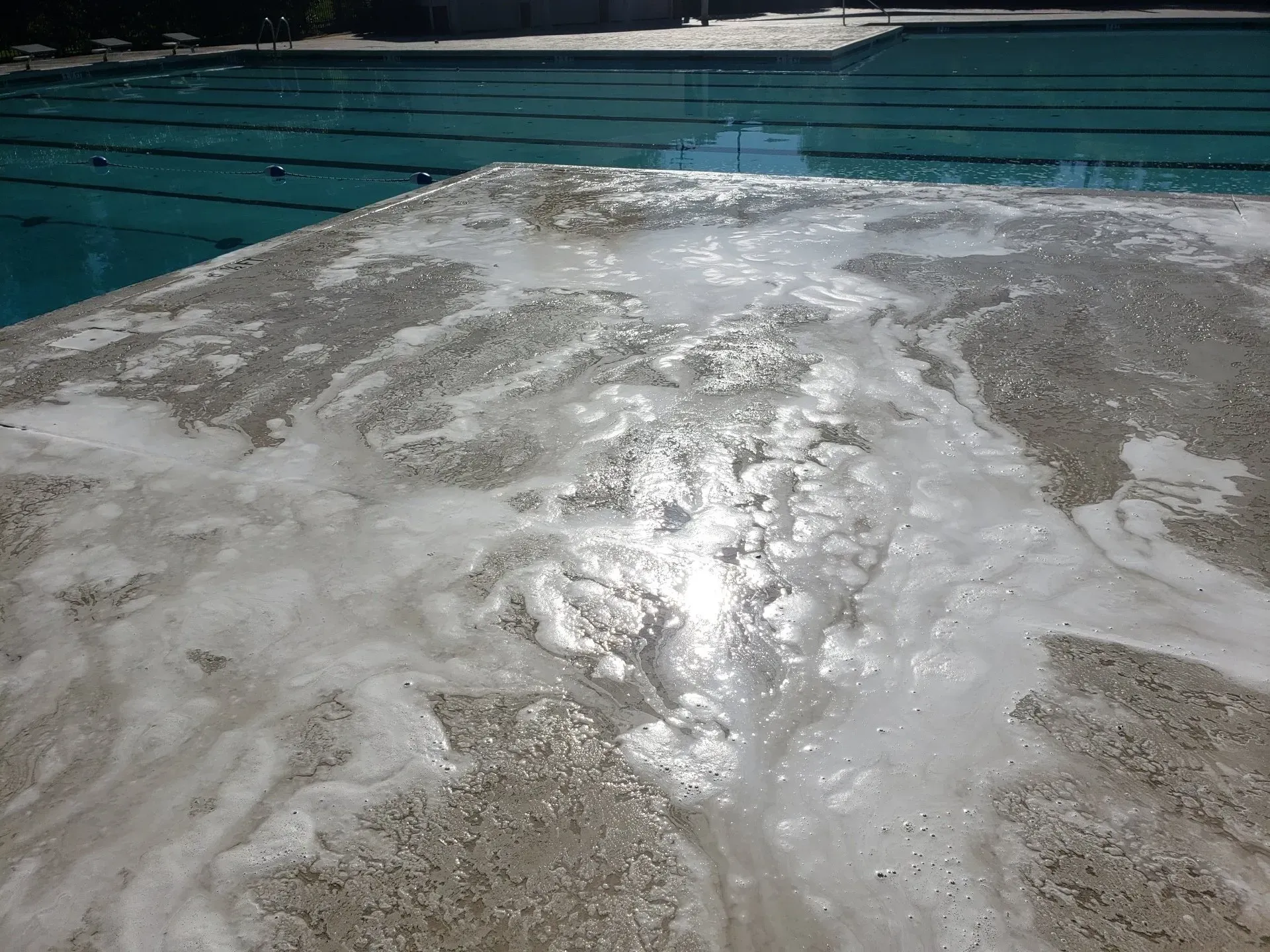 A swimming pool with a lot of foam on the floor