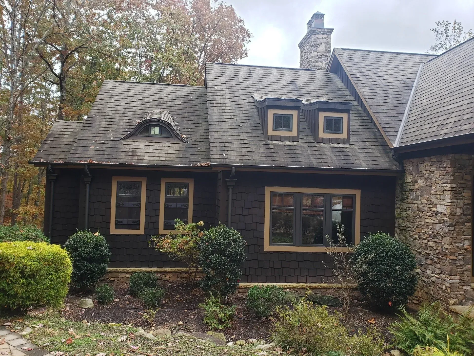 A large house with a roof that has a lot of windows and a chimney.