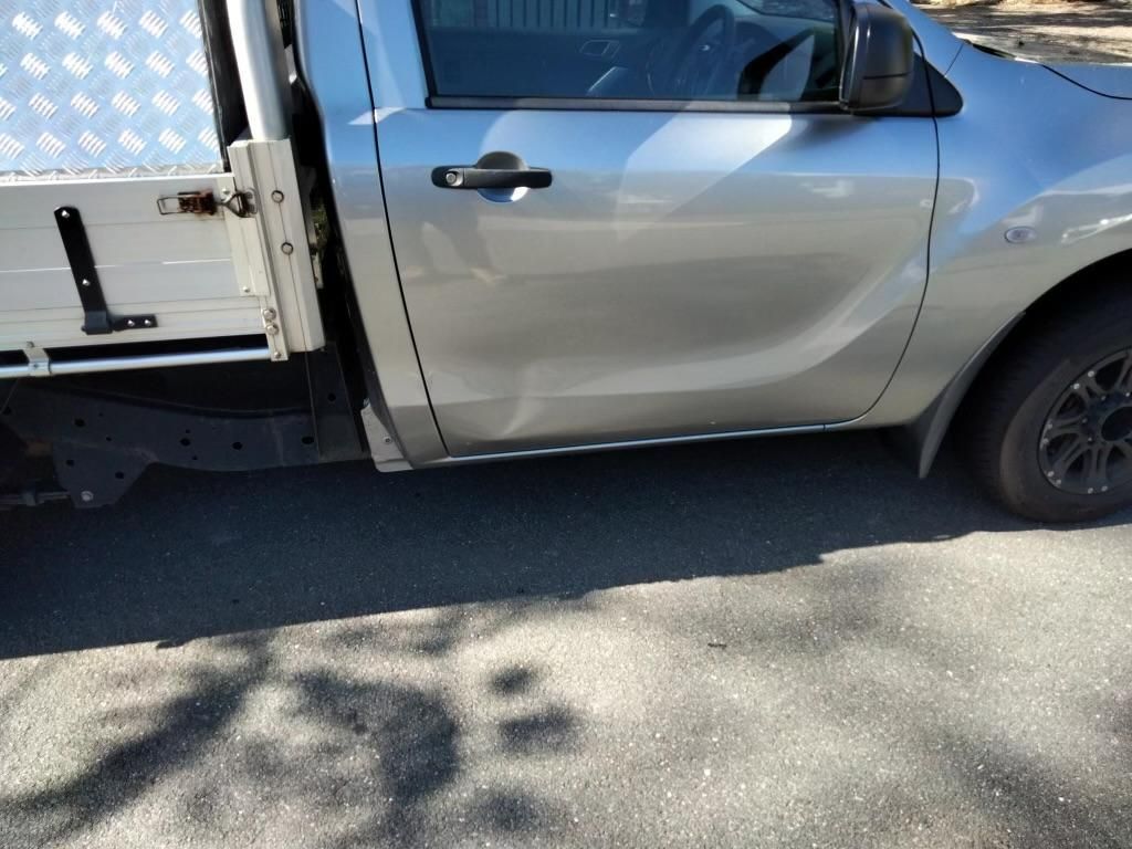 A Dented Silver Truck Is Parked on The Side of The Road — Dent Repair Specialist in Maroochydore, QLD