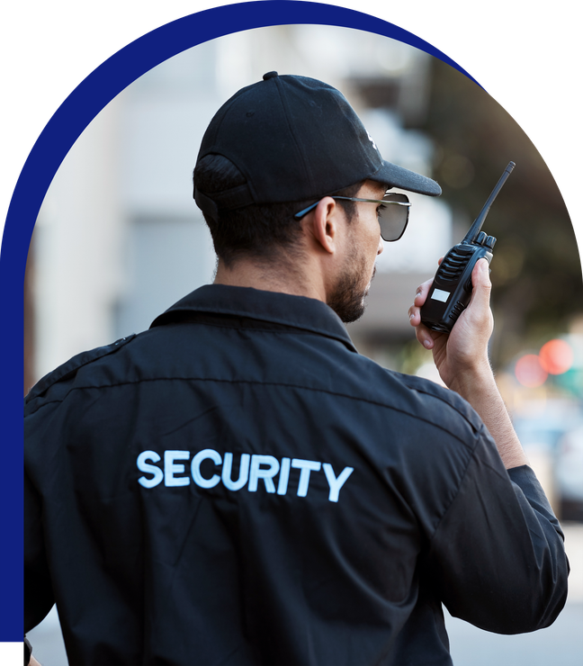 A security guard is talking on a walkie talkie