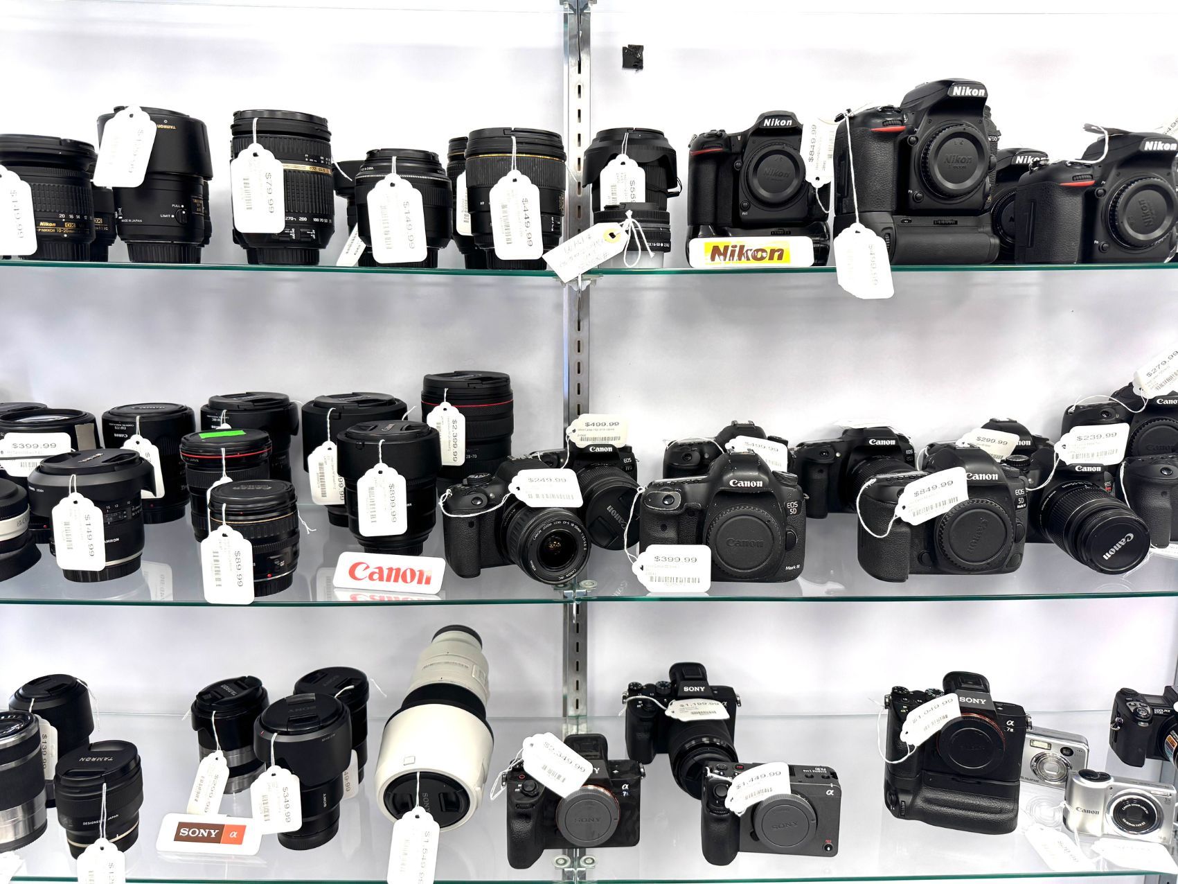 Camera lenses image, preowned camera lens facing  camera on wooden table with yellow wall out of focus in background