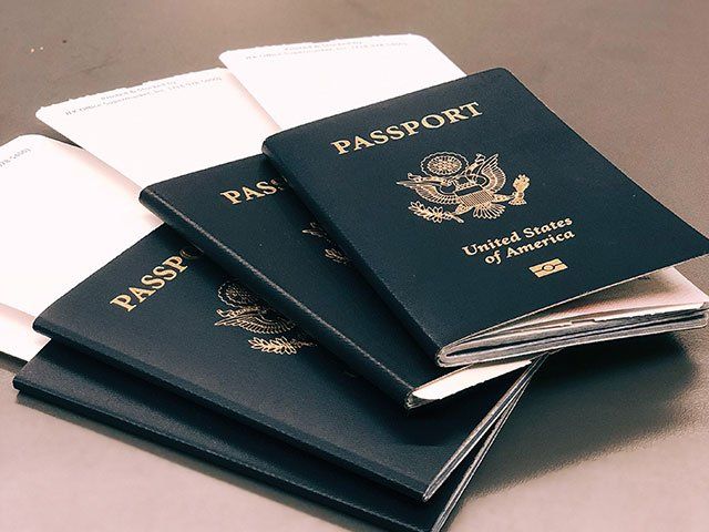Passport Photo services image, picture of several US passports fanned out on a grey surface.