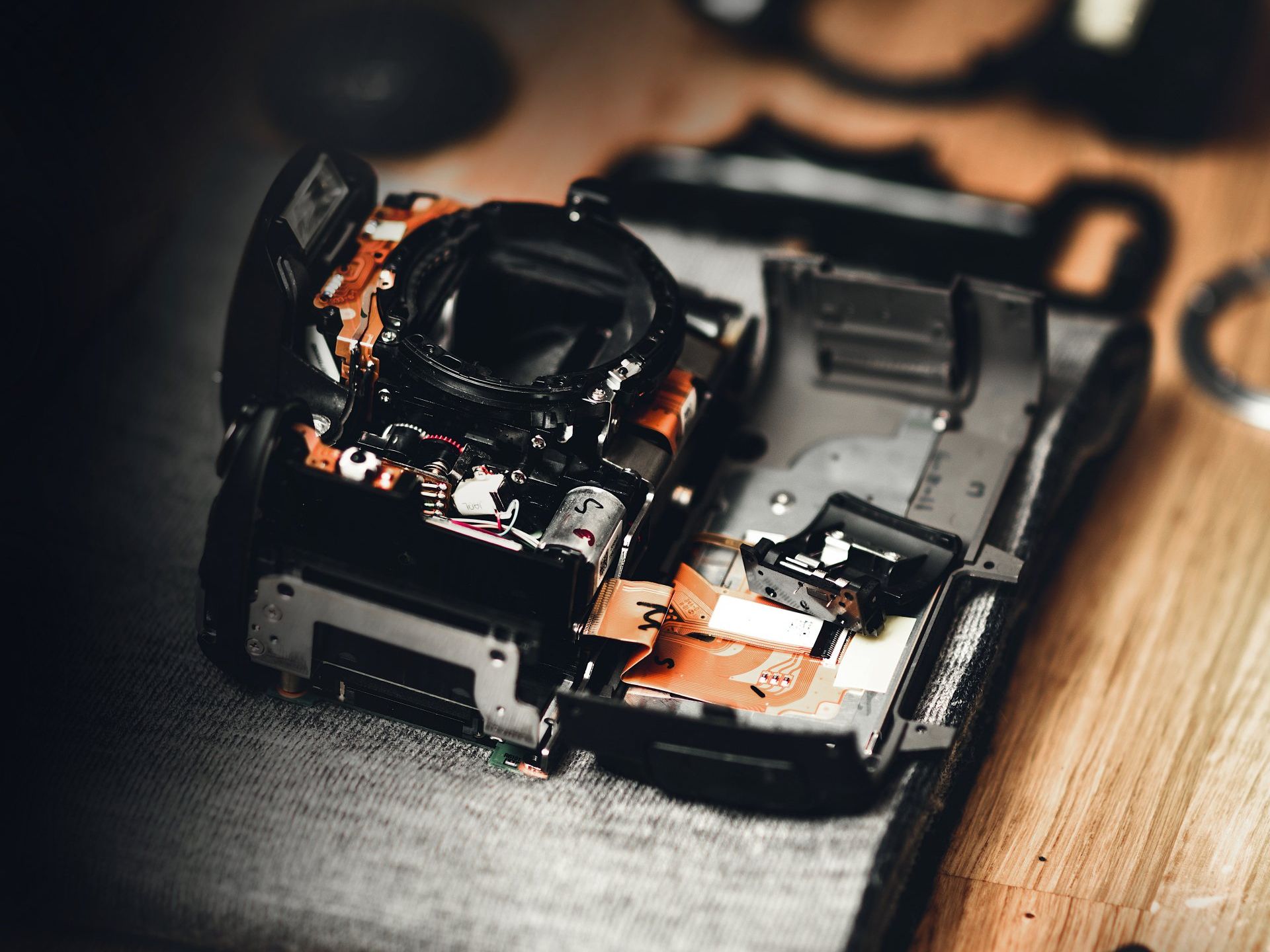 Camera Repair image, dslr camera taken apart on a wooden table