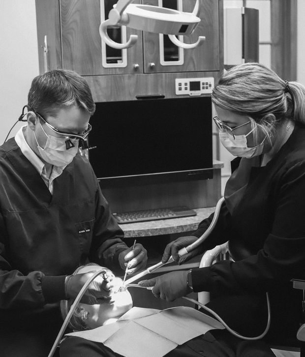 Dentist in blue gloves holding a dental implant in a clinic Dentist in blue gloves holding a dental implant in a clinic