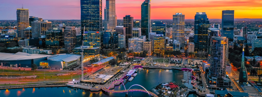 Sunset view of the Perth skyline featuring modern skyscrapers overlooking the waterfront at Elizabeth Quay.