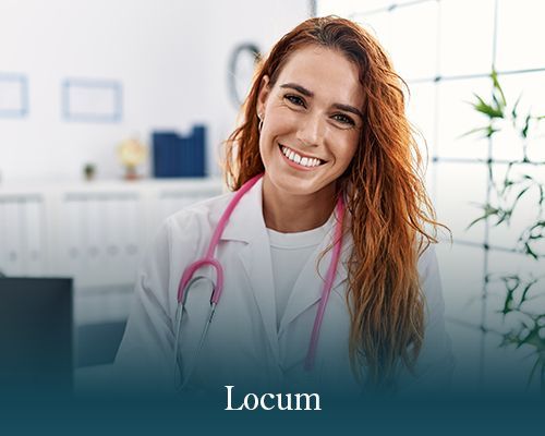 A smiling medical professional wearing a white lab coat and a pink stethoscope in an office setting.