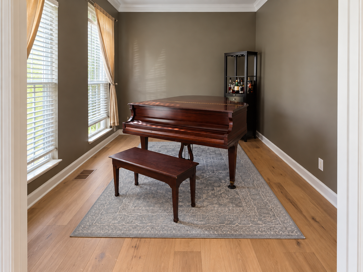 Narrow hallway with wood floors, white stairs, blue cabinets, and storage boxes along the walls