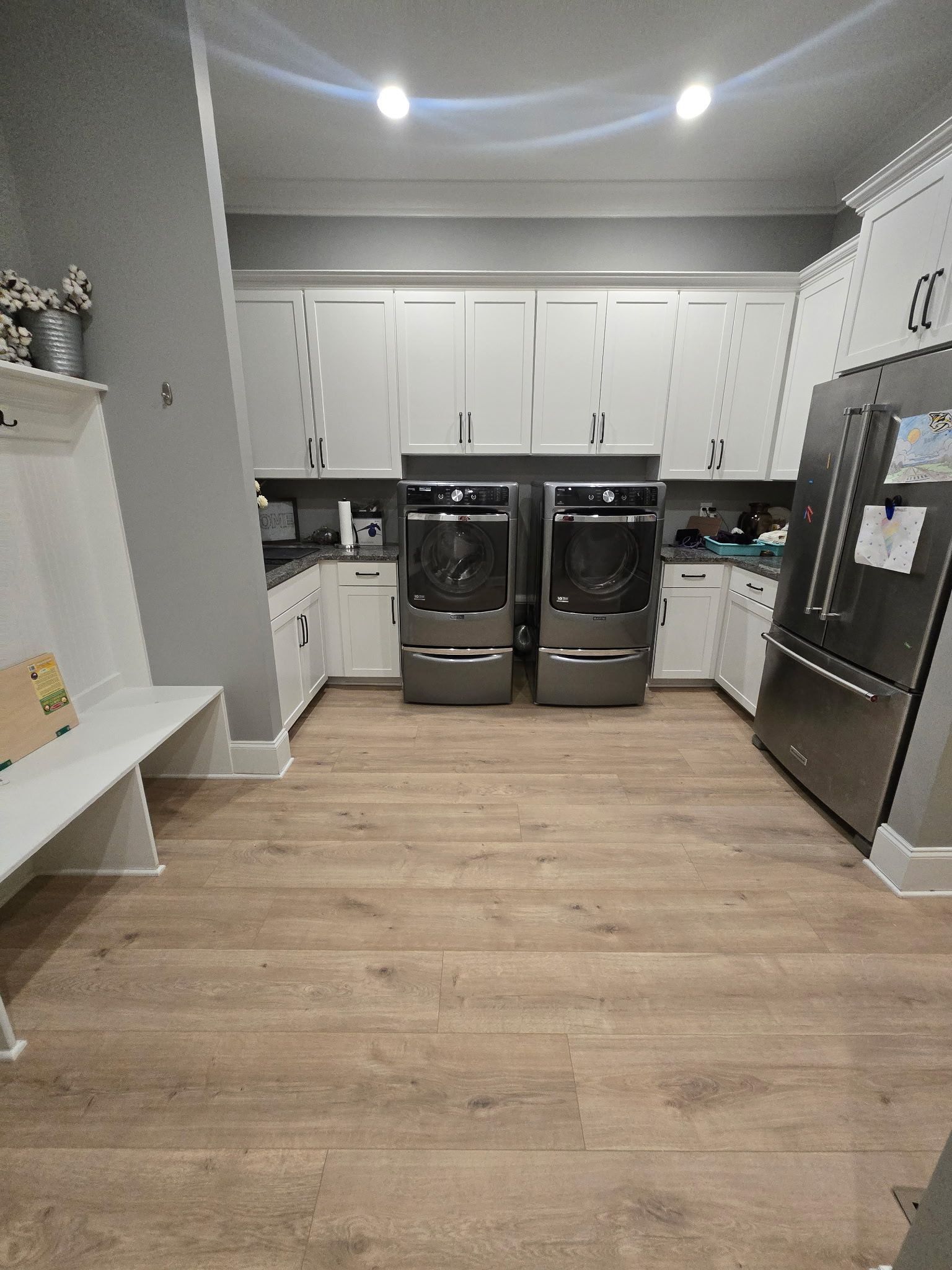 Modern kitchen with white cabinets, black appliances, and light wood flooring