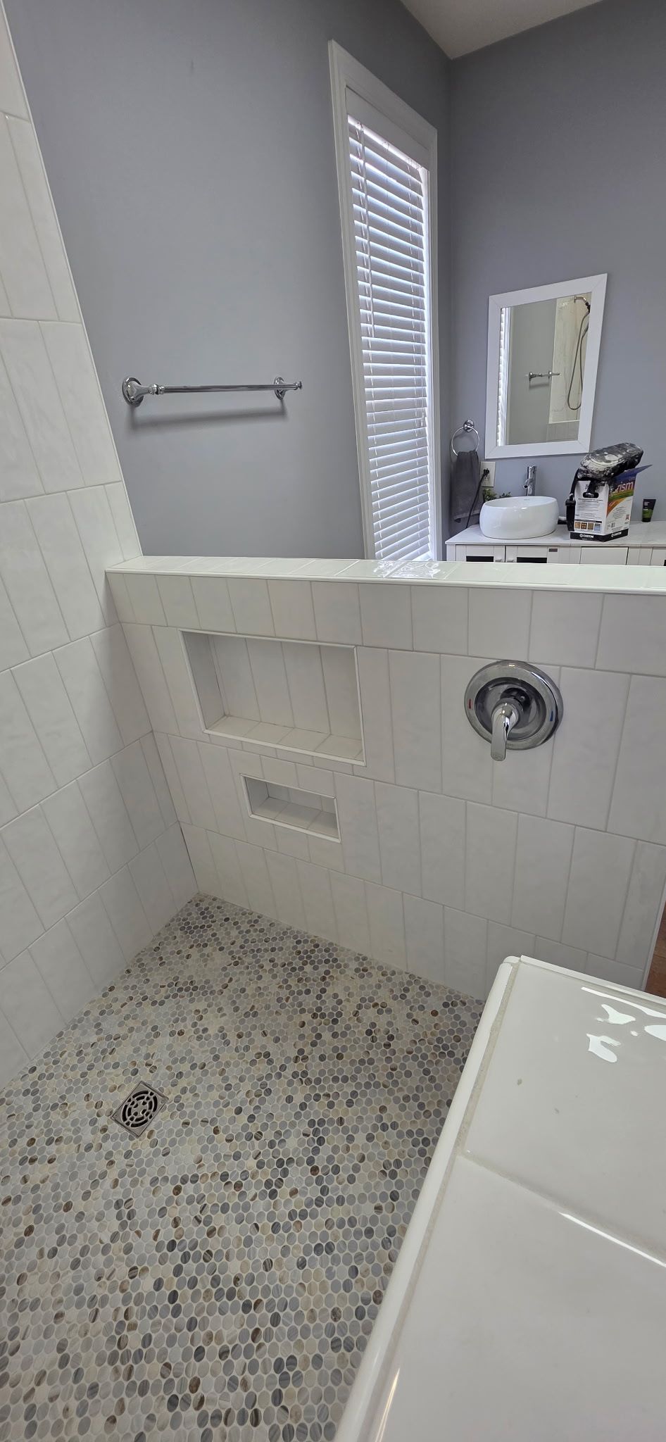 Small bathroom with a white toilet beside a tiled shower stall.