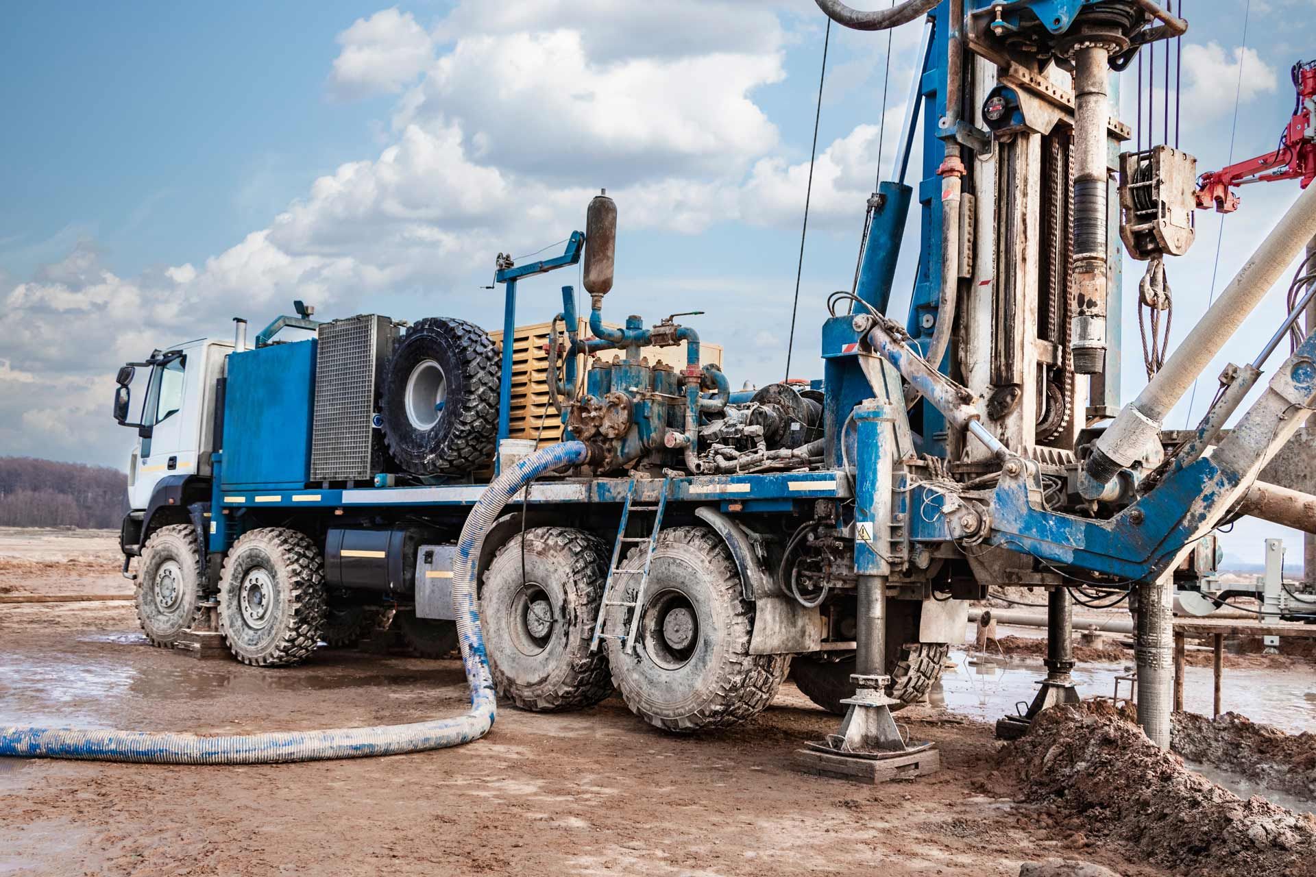 Blue drilling rig on muddy ground