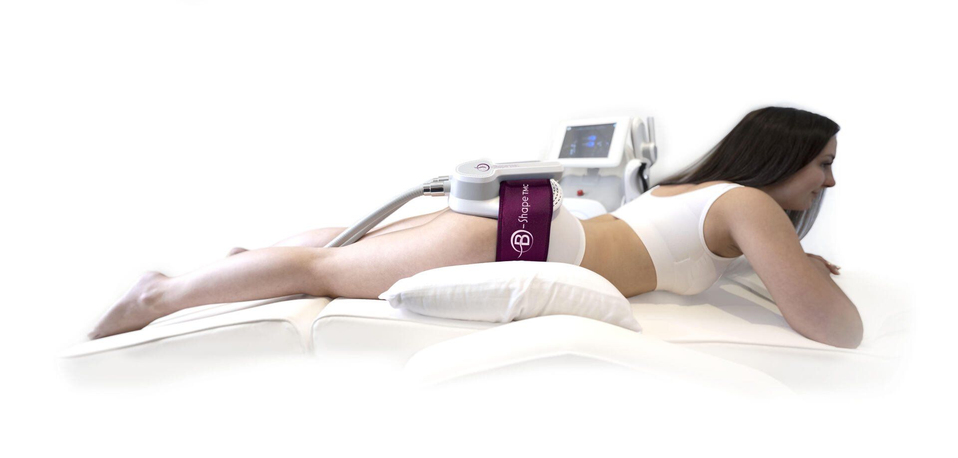 Woman receiving body sculpting treatment while lying on a table.