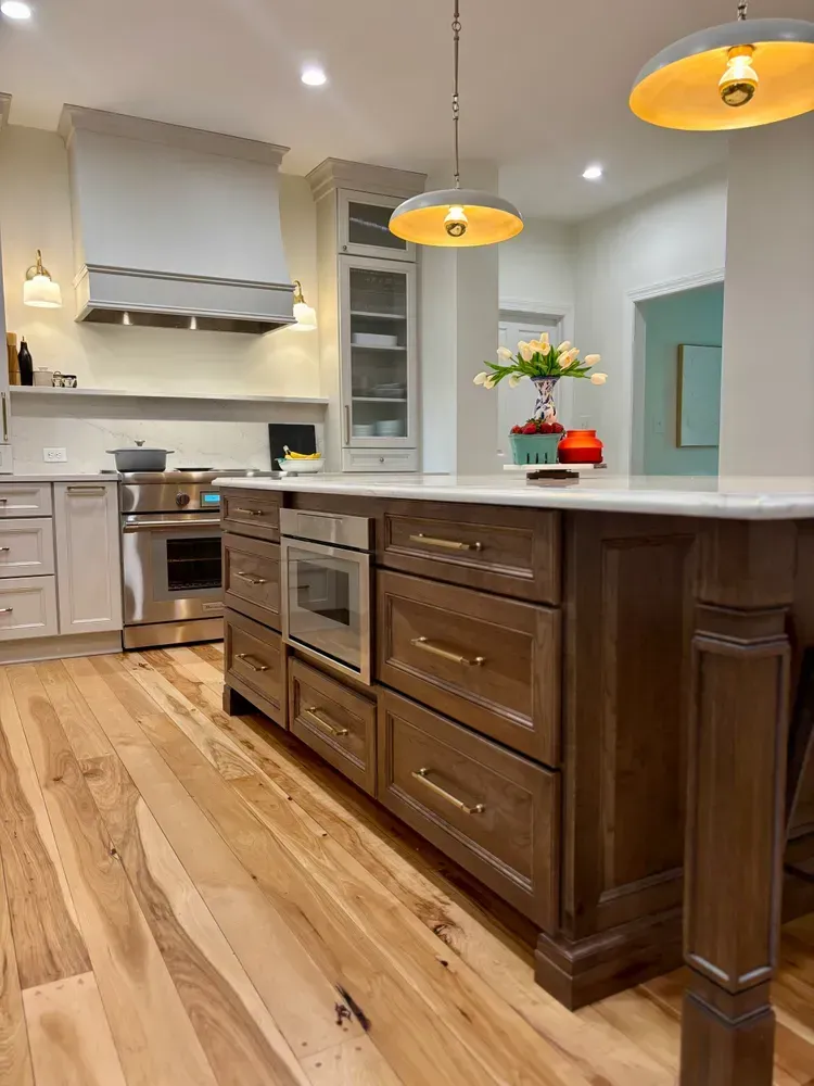 Modern kitchen with dark wood island, stainless appliances, light countertops, and hardwood floors