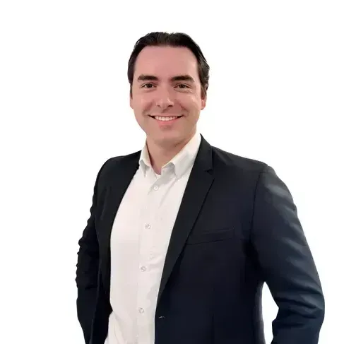 A man in a suit and white shirt is smiling for the camera.