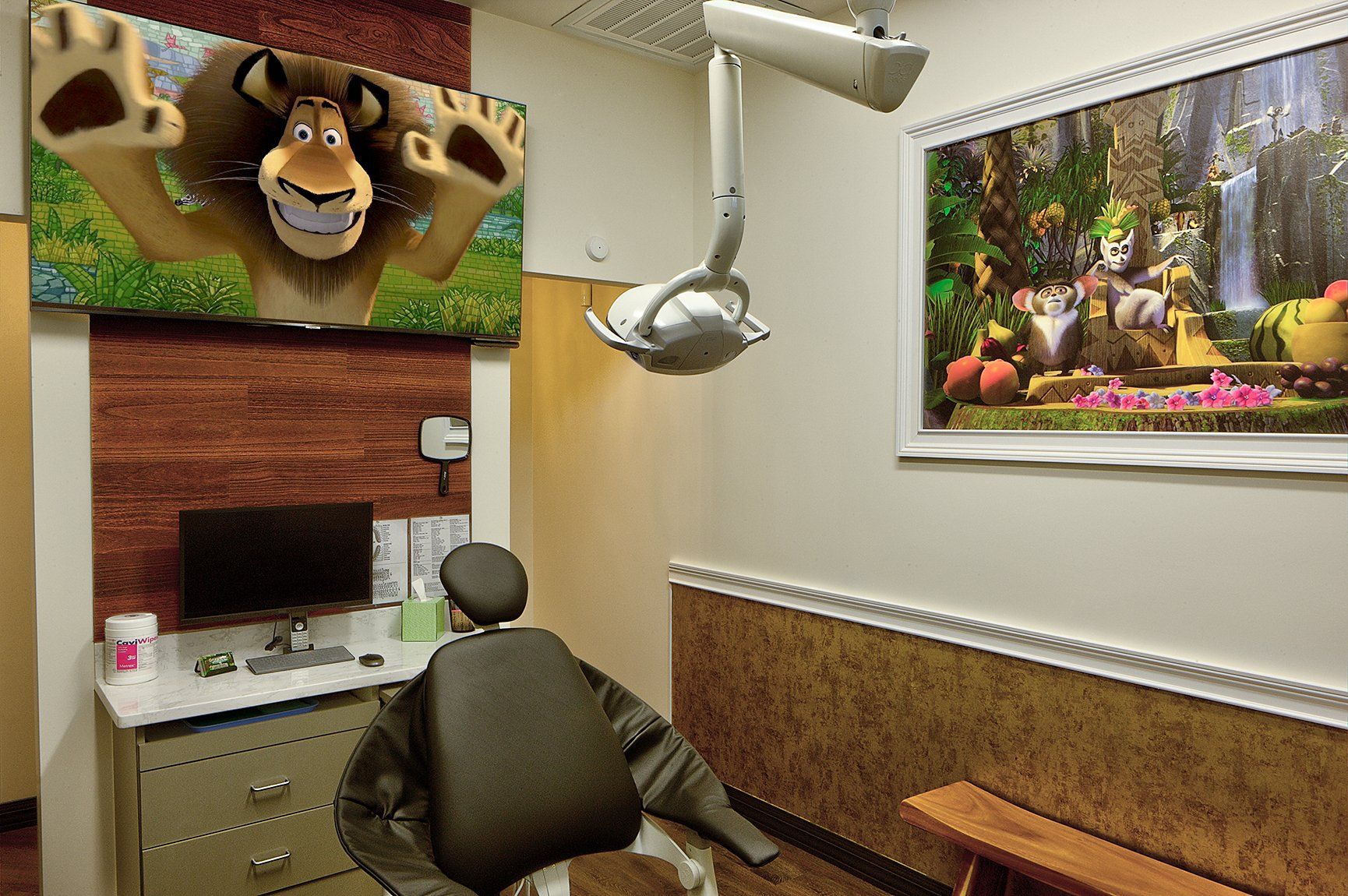 Animal-themed office cubicle with a desk, chair, and framed waterfall landscape art; no person present